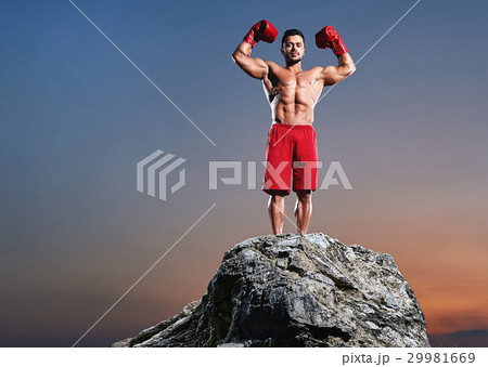 Muscular male boxer training outdoors 29981669