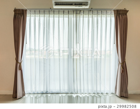 Light shines through white curtains in room 29982508