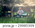 Old man sitting at a desk on a outdoor 29985309