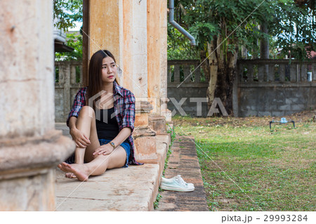 woman sitting on the cement floor. 29993284