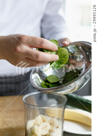 Crop hands making fresh smoothie Crop hands making fresh smoothie 29995126