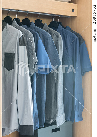 clothes hanging on rail in wooden wardrobe clothes hanging on rail in wooden wardrobe 29995702