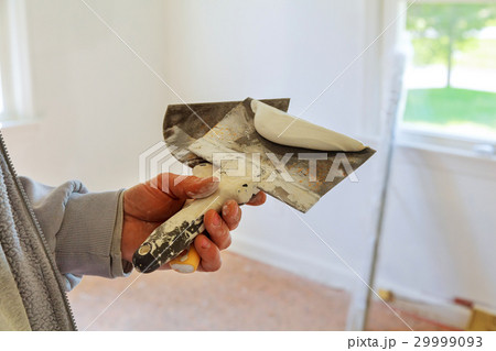 Painting worker puttied wall using a paint spatula Painting worker puttied wall using a paint spatula 29999093
