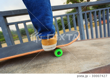 skateboarder legs riding skateboard at skatepark 30007427