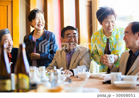 シニア同窓会 食事を楽しむ男女の写真素材