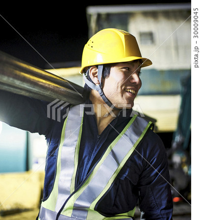 建設現場 夜間 パイプを運ぶ男性 建設現場 夜間 パイプを運ぶ男性 30009045
