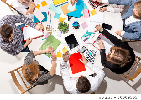 Team sitting behind desk, checking reports Team sitting behind desk, checking reports 30009565