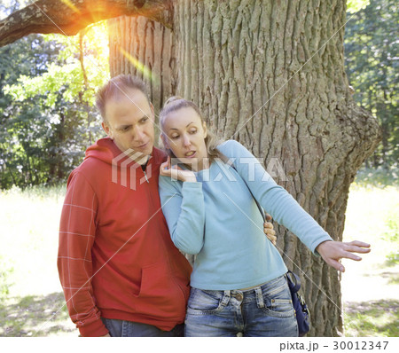 man and  woman near an oak in summer  day somethin 30012347