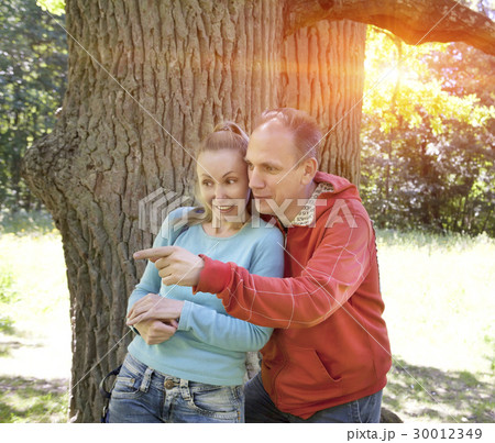 man and  woman near an oak in summer  day somethin 30012349