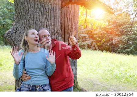 man and  woman near an oak in summer  day have see 30012354