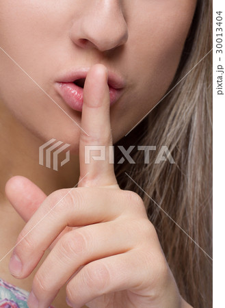 Close-up image of woman with finger on her lips 30013404