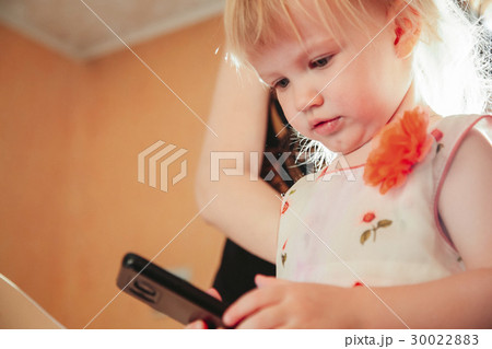 Little girl playing in gadget 30022883