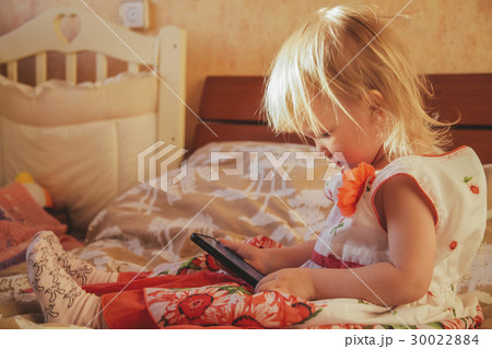 Little girl playing in gadget 30022884