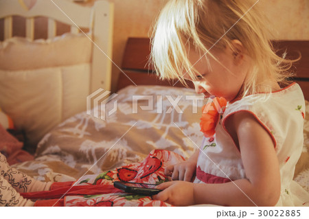 Little girl playing in gadget 30022885