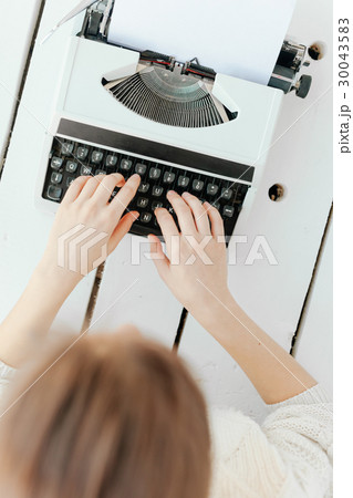 woman's hand typing on retro machine woman's hand typing on retro machine 30043583