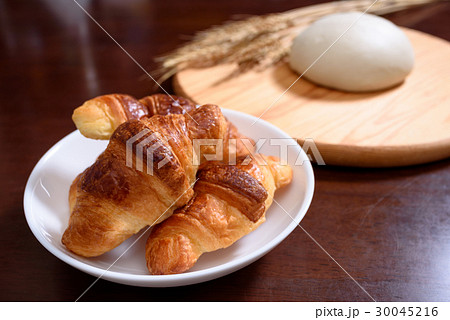 クロワッサンとカッティングボードの上のパン生地と小麦 クロワッサンとカッティングボードの上のパン生地と小麦 30045216