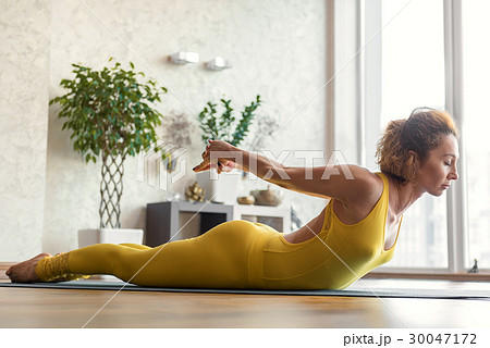 Cheerful female yogi exercising in morning 30047172