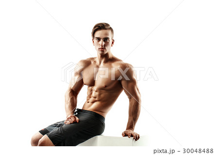 Handsome muscular male model sitting on a cube and 30048488