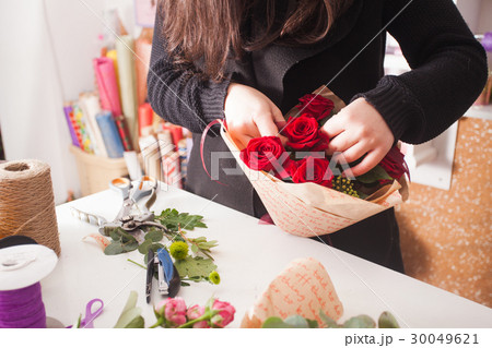 Florist making bouquet of red roses Florist making bouquet of red roses 30049621