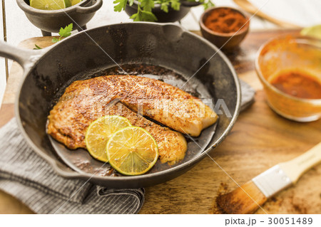 Tilapia on frying pan 30051489