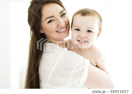 Mother carrying son (4-5) and smiling 30051657