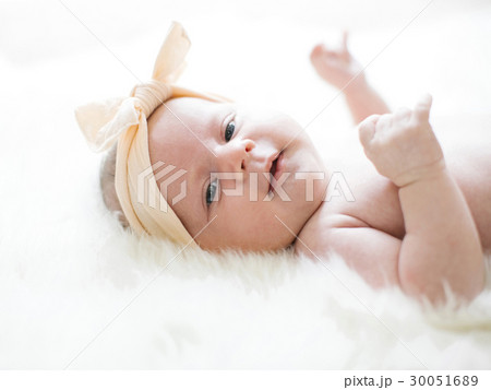 Portrait of girl (0-1 months) with ribbon on head 30051689