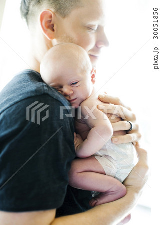 Portrait of man holding his on day son (0-1 months) 30051856