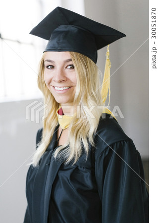 Portrait of young blond woman wearing graduation gown Portrait of young blond woman wearing graduation gown 30051870