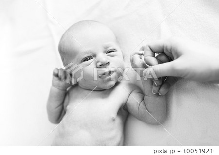 Portrait of newborn boy ( 0-1 months ) holding mother's hand 30051921