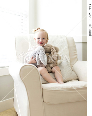 Portrait of girl ( 12-17 months ) holding stuffed toys 30051943