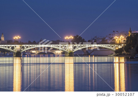 Spain, Seville, Triana, Guadalquivir River and Puente de Isabel II at dusk 30052107