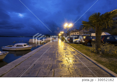 Croatia, Dalmatia, Sibenik, Empty sidewalk by harbor at dusk 30052162