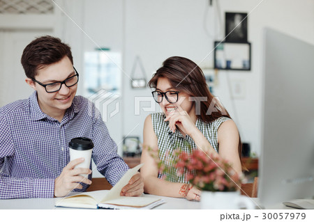 Two creative designers working at white office. 30057979