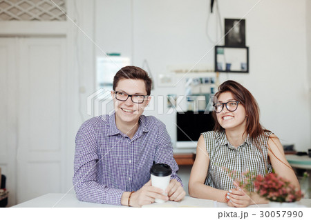 Two creative designers working at white office. 30057990