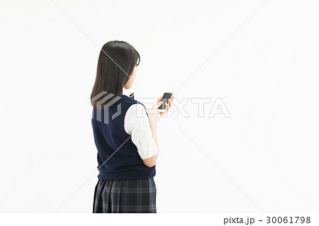 中学生 女子 制服 スマホ 後ろ姿の写真素材