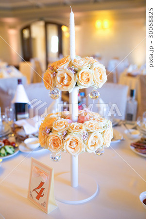 Beige roses decorate white candleholder standing Beige roses decorate white candleholder standing 30068825