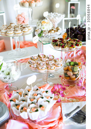 Table with delicious sweets covered with pink silk Table with delicious sweets covered with pink silk 30068844