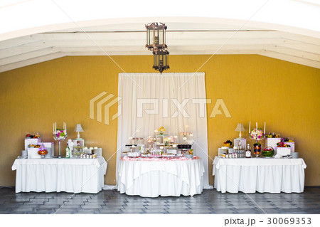 Three white tables served with snacks and sweets 30069353