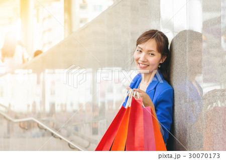 Youung woman carrying shopping bags at street 30070173