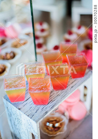Pretty colorful jellies served in square glasses Pretty colorful jellies served in square glasses 30070288
