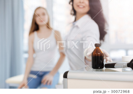 Helpful nurse using iodine for skin disinfection 30072968
