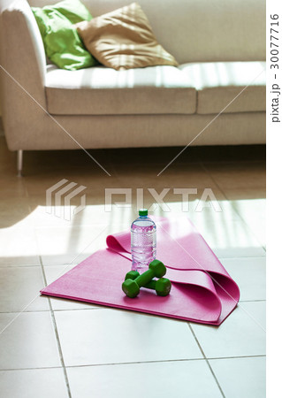 Fitness tools with mineral water on yoga mat Fitness tools with mineral water on yoga mat 30077716