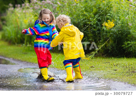 Kids play in rain and puddle in autumn 30079727