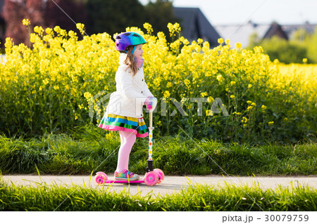 Child riding schooter on way to school 30079759