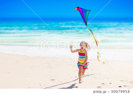 Child flying kite on tropical beach 30079958