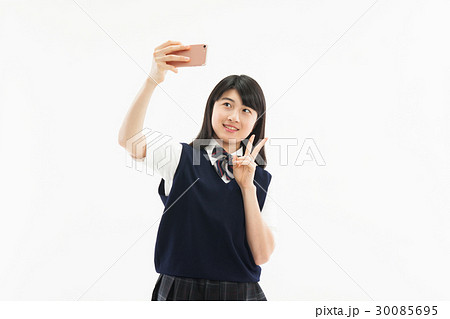 中学生 女子 制服 スマホ 自撮りの写真素材
