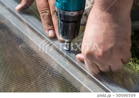 Worker screwing screw into polycarbonate 30090509