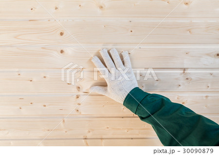 Human palm in gloves on tongue and groove wall 30090879
