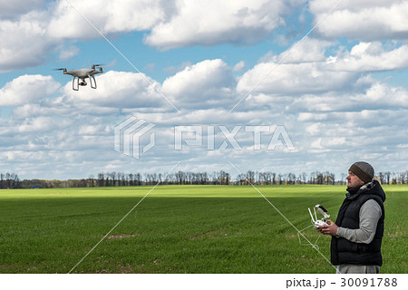 man operating of flying drone quadrocopter at the 30091788