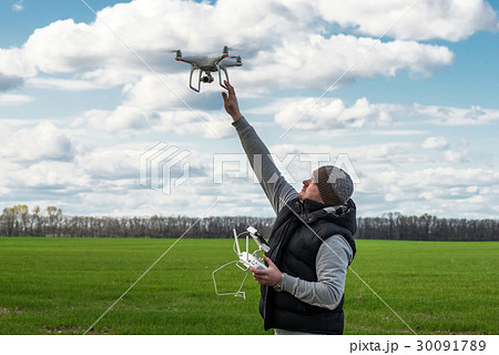 man holding of flying drone quadrocopter at the 30091789